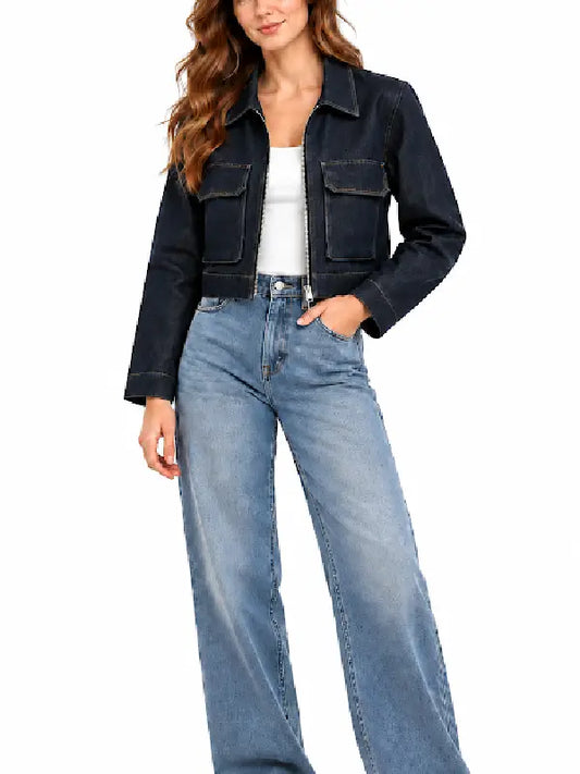 Woman wearing a dark indigo cropped denim jacket with zip front and chest flap pockets over a white top