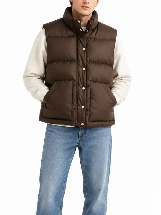 Man wearing brown quilted puffer vest over cream hoodie, front view