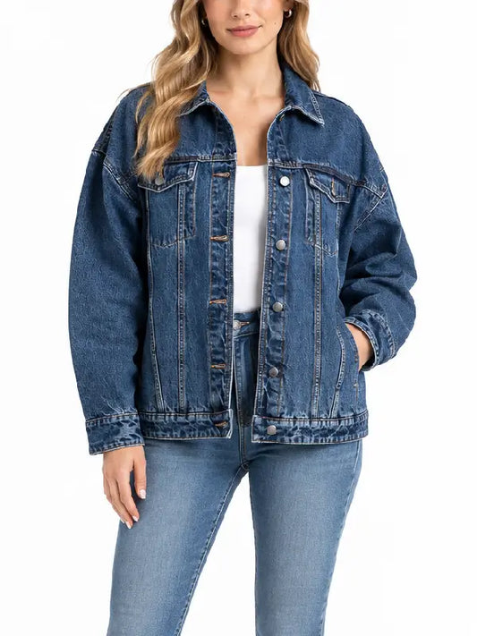 Woman wearing oversized medium wash denim trucker jacket, front view, unbuttoned