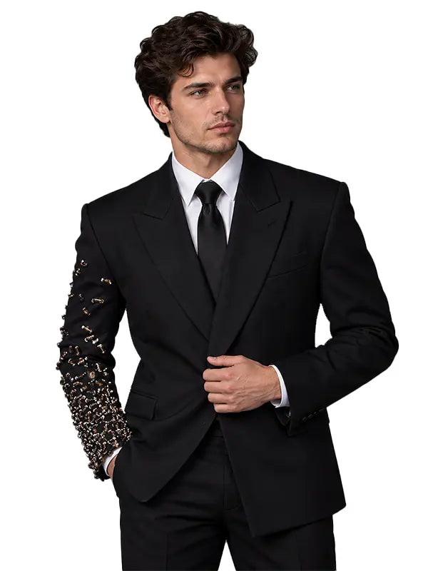 Men's black tailored suit with intricate crystal and metallic embellishment covering one sleeve, white shirt and black tie, full-length studio view.