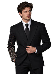 Men's black tailored suit with intricate crystal and metallic embellishment covering one sleeve, white shirt and black tie, full-length studio view.