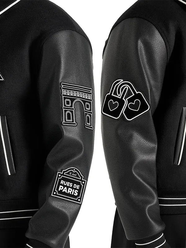 Close-up of black wool varsity jacket with leather sleeves, contrast piping and embroidered patches