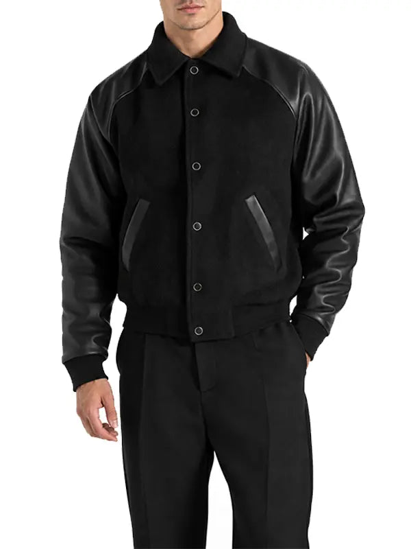 Men's black wool and leather raglan letterman jacket with snap-button closure and angled pockets.
