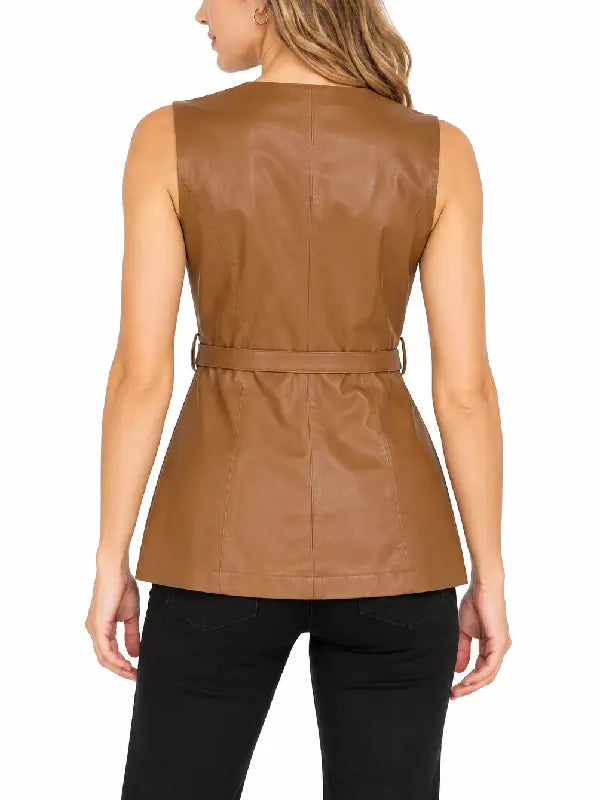 Back view of woman wearing a tan leather belted vest with back seams and black pants