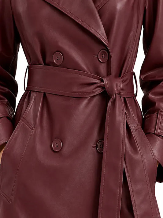 Close-up of burgundy real leather trench coat showing double-breasted buttons, tie belt and side pocket