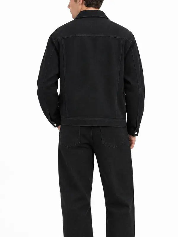 Back view of a men's black denim jacket with yoke seam, shirt-style collar, and button cuffs
