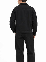 Back view of a men's black denim jacket with yoke seam, shirt-style collar, and button cuffs