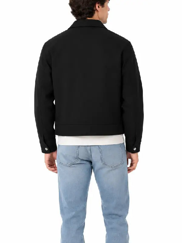 Back view of men's black cropped jacket with button cuff tabs, worn with a white tee and light-wash jeans