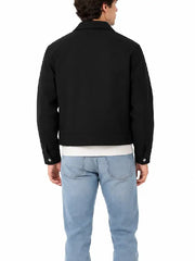 Back view of men's black cropped jacket with button cuff tabs, worn with a white tee and light-wash jeans