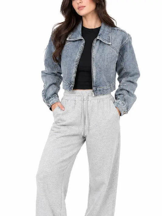 Front view of women's blue zip-up cropped denim jacket with shirt collar, worn with a black crop top