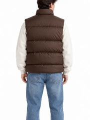 Back view of man wearing brown quilted puffer vest over cream hoodie