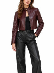 Front view of women’s burgundy cropped zip-up jacket with stand collar, snap tab, and side flap details