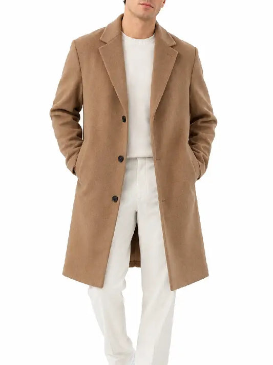 Front view of a man wearing a camel button-front overcoat with notch lapel over a white sweater