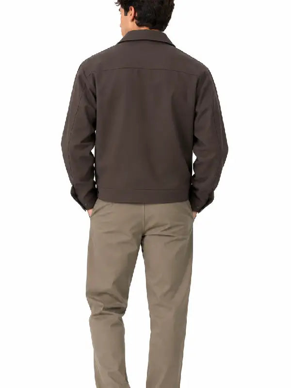 Back view of a man wearing a dark brown cropped collared jacket 