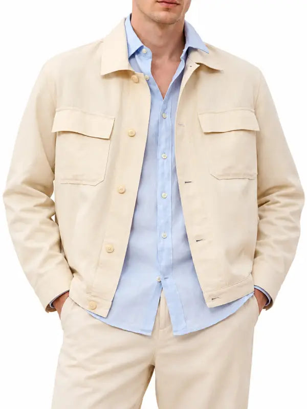 Front view of men's beige cotton jacket with button closure and chest flap pockets styled over a light blue shirt