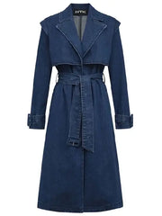 Front view of women's blue denim trench coat with notched collar, button closure, and belted cuffs