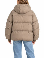 Back view of taupe oversized hooded puffer jacket showing quilted paneling and hood