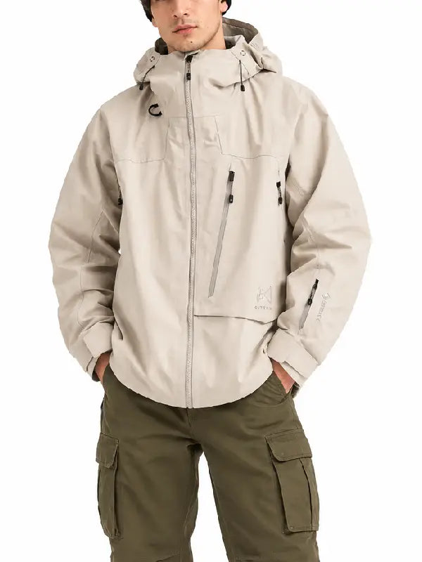 Man wearing a beige GORE-TEX waterproof hooded jacket with zippered chest pocket and sleeve pocket, styled with camo pants