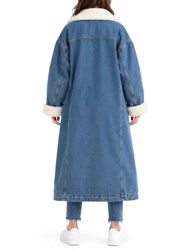 Back view of women’s long blue denim coat with sherpa collar and folded sherpa cuffs