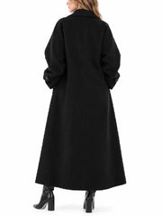Back view of a woman wearing a black oversized maxi wool blend coat with button tab cuffs, styled with black heeled boots