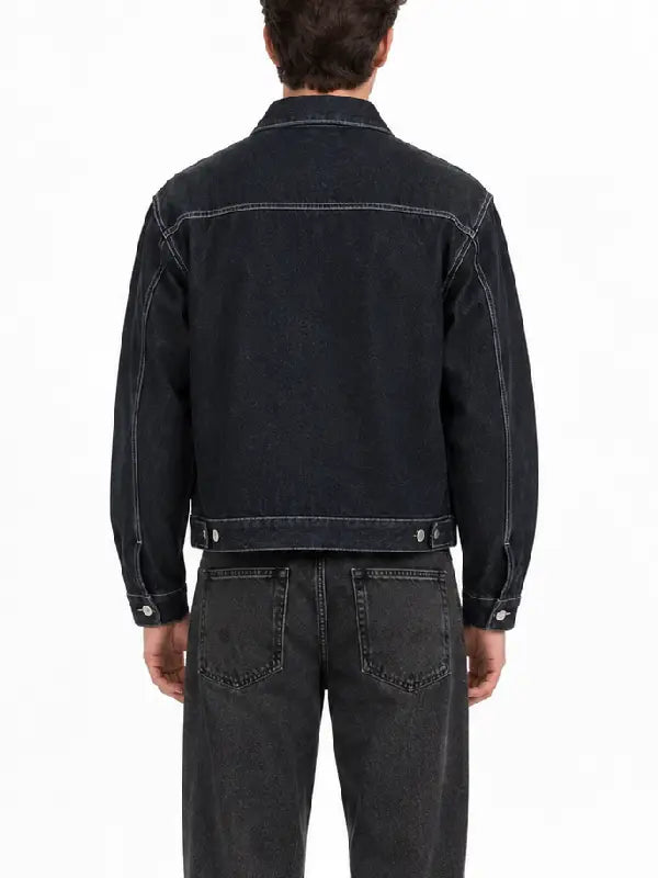 Back view of a men's dark denim jacket with contrast stitching, yoke seam, and button waist adjusters