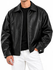 Close-up front view of a men’s black leather bomber jacket showing the shirt collar, zipper and snap cuff detail
