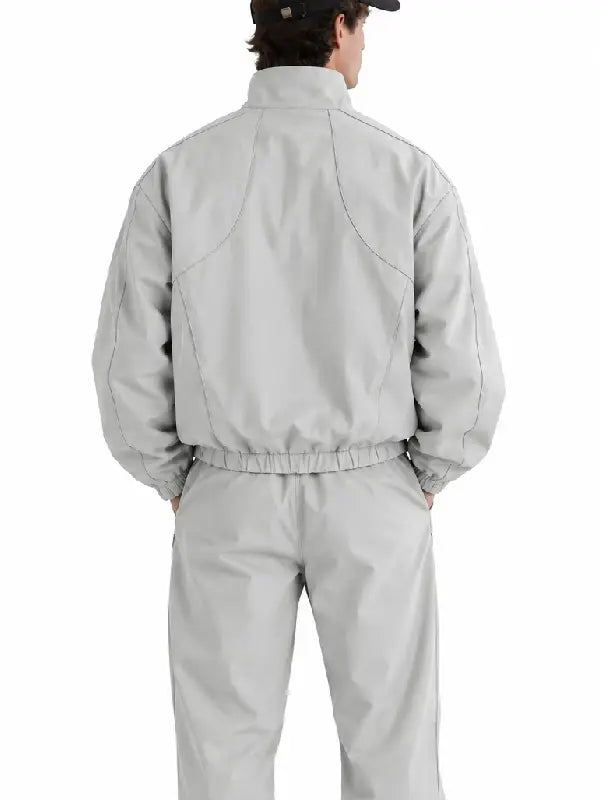 Back view of man wearing light grey oversized track jacket and pants set