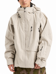 Man wearing a beige GORE-TEX waterproof hooded jacket with zippered chest pocket and sleeve pocket, styled with camo pants