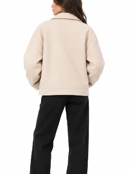 Back view of women's beige oversized biker jacket with dropped shoulders, worn with black pants
