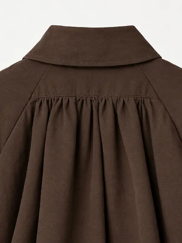 Close-up of brown jacket collar and shoulder pleating detail