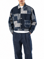 Man wearing patchwork denim cropped jacket, front view, hands in pockets