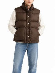 Man wearing brown quilted puffer vest over cream hoodie, front view