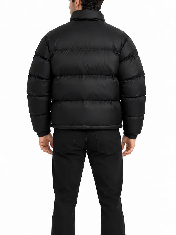 Back view of a men's black quilted puffer jacket with horizontal quilting and high stand collar