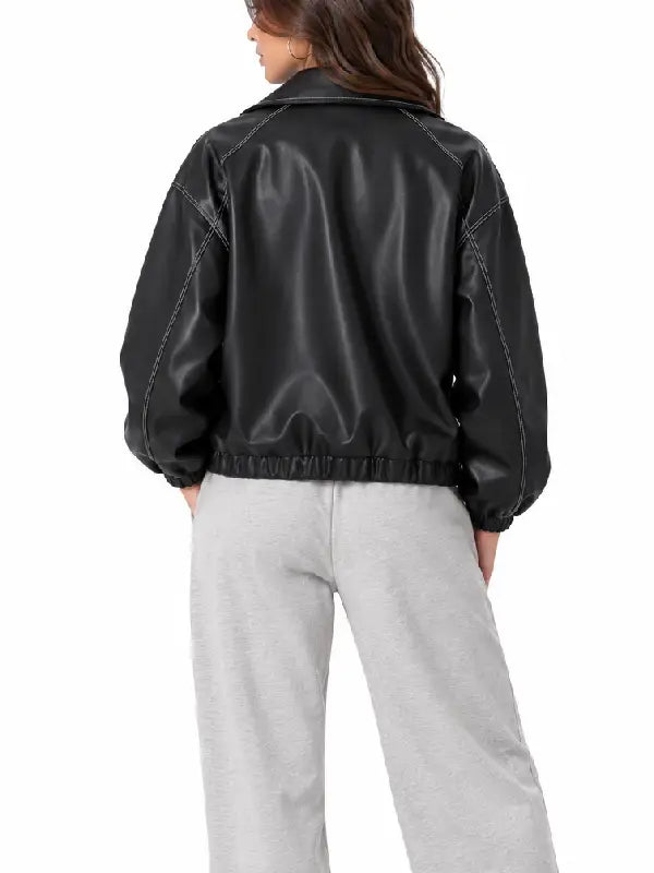Back view of a women’s black oversized leather bomber jacket with white contrast stitching and elastic hem
