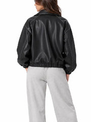 Back view of a women’s black oversized leather bomber jacket with white contrast stitching and elastic hem