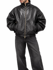 Front view of a men’s black leather bomber jacket with ribbed cuffs and hem, styled with washed black jeans
