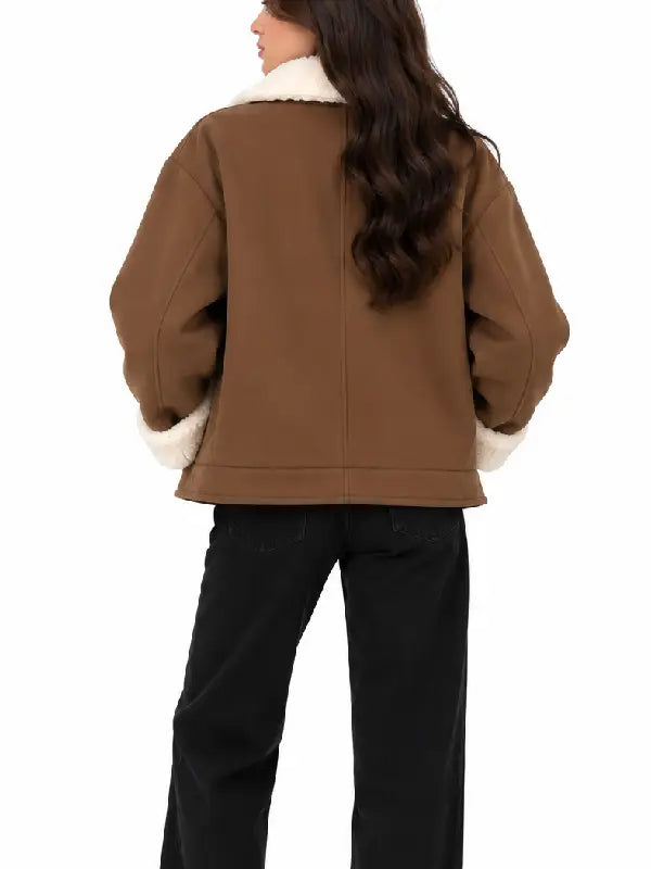 Back view of women's brown short coat with cream sherpa collar and cuffs, worn with black jeans