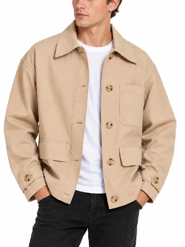 Front view of man wearing a beige chore jacket with button front, chest pocket and flap pockets over a white tee