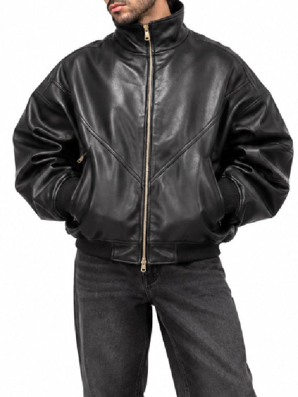 Man wearing an oversized black leather bomber jacket with stand collar and gold zip front, close-up front view