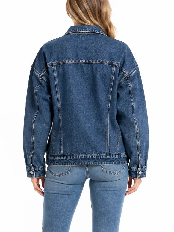 Back view of oversized medium wash denim trucker jacket showing seam detailing