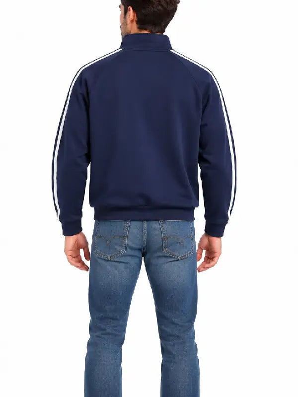 Back view of man wearing navy striped track jacket with jeans