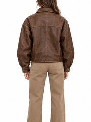 Back view of women’s oversized vintage brown leather jacket with snap button cuffs