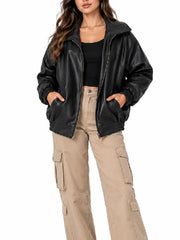 Woman wearing an oversized black leather bomber jacket with zip front, ribbed cuffs and ribbed hem, front view
