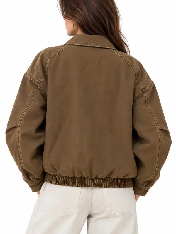 Back view of women's brown vintage canvas bomber jacket with elastic hem and dropped shoulders