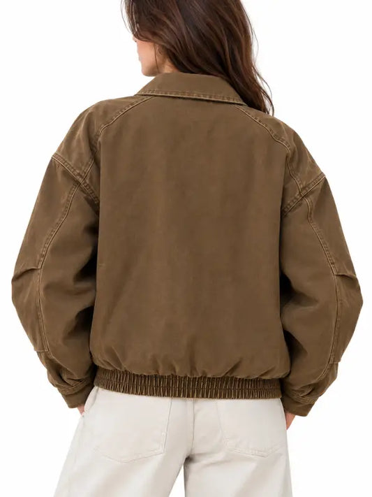 Back view of women's brown vintage canvas bomber jacket with elastic hem and dropped shoulders
