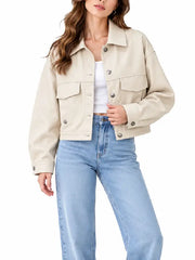 Front view of women’s cream cropped button jacket with shirt collar, chest flap pockets, and snap closure worn with light-wash jeans