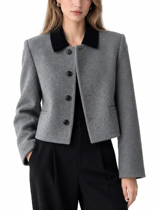 Front view of women's grey button-up woolen jacket with contrast velvet collar and welt pockets styled with black trousers