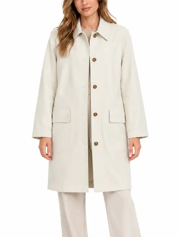 Front view of woman wearing ivory collared topcoat with flap pockets
