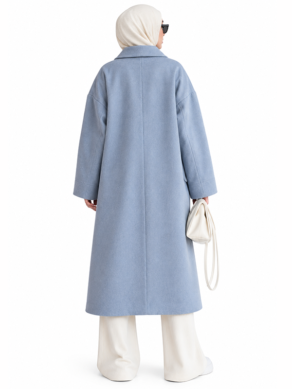 Back view of women’s long light blue wool coat with center back seam and wide sleeves